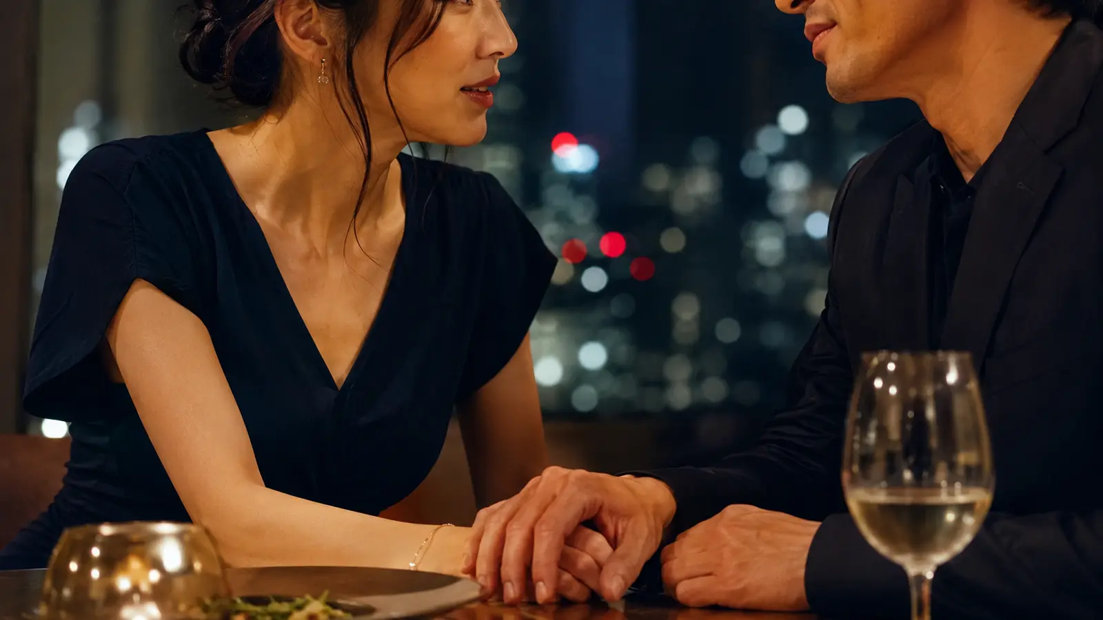 夜のレストランで親しげに話す30代女性と男性